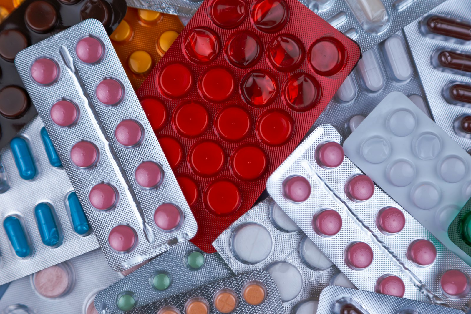 Blister packs of tablets and capsules stacked together.